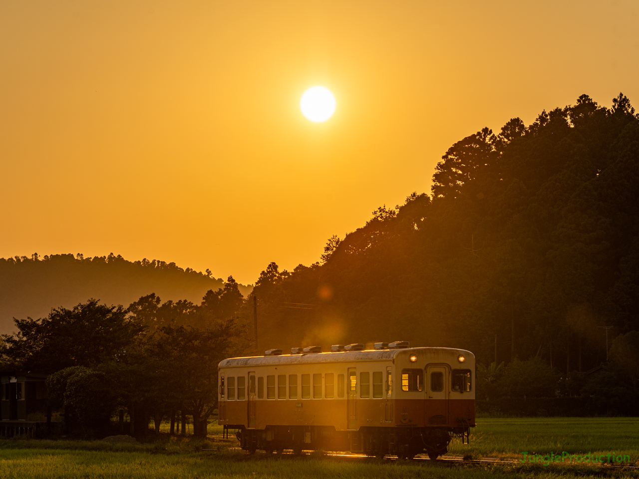 傾いた太陽と１両編成の気動車