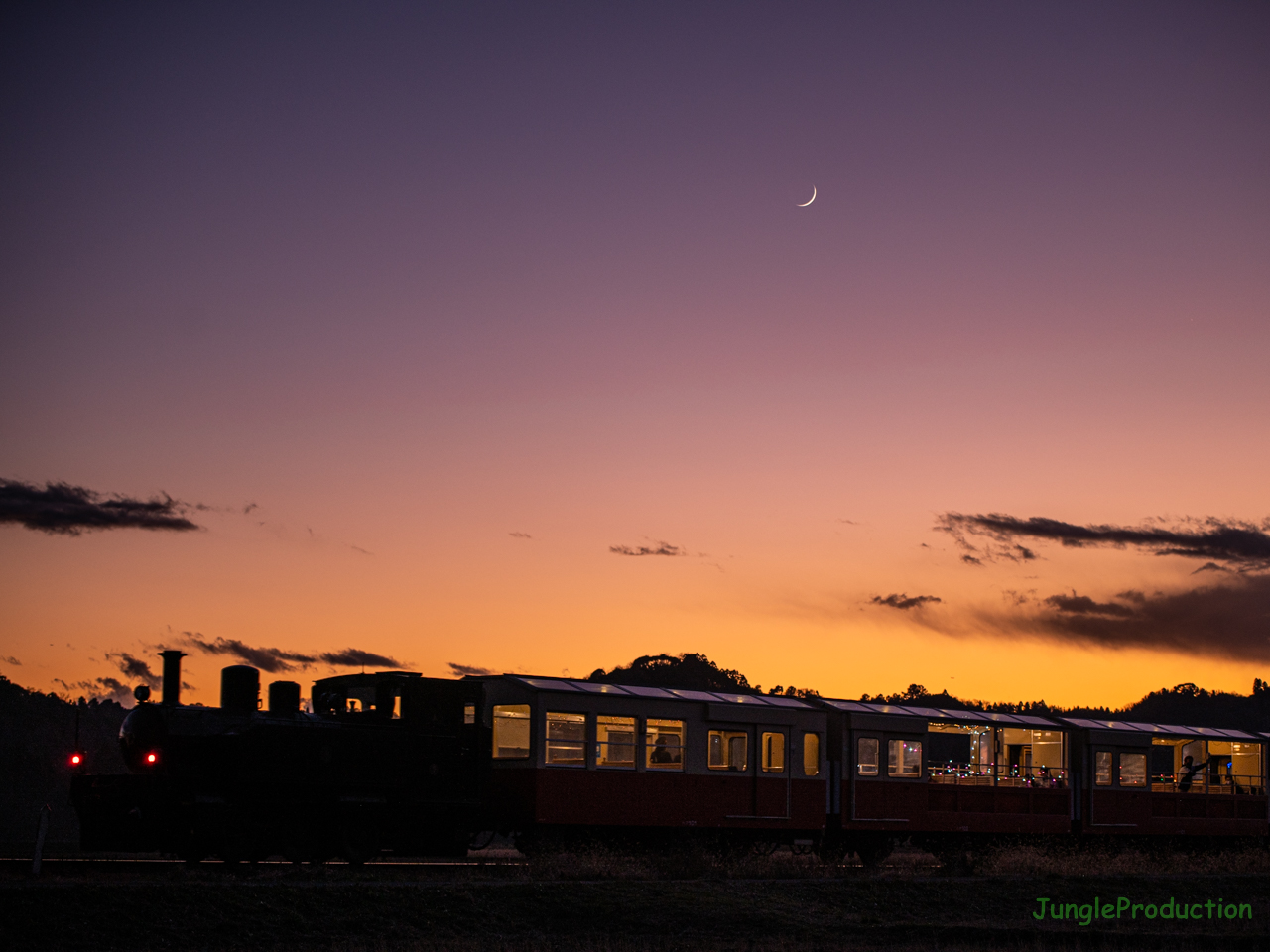 夕焼けグラデーションの下をいく里山トロッコ列車